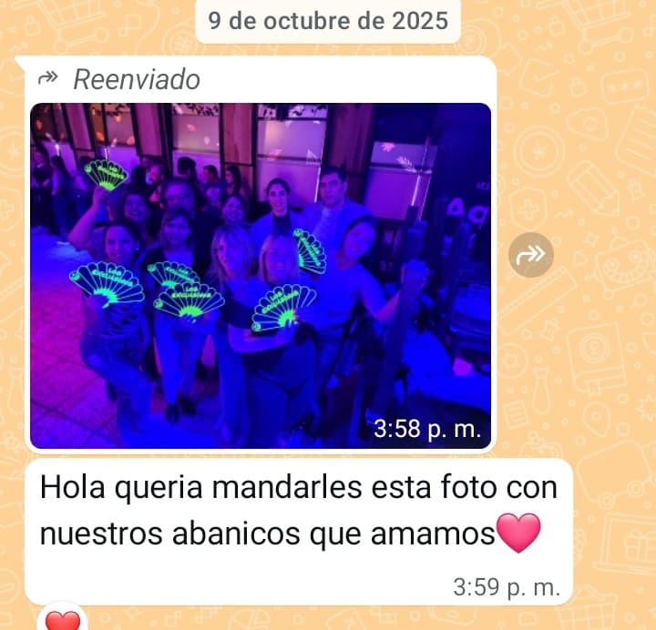 Mensaje de clienta con foto grupal usando abanicos personalizados que brillan en un evento nocturno